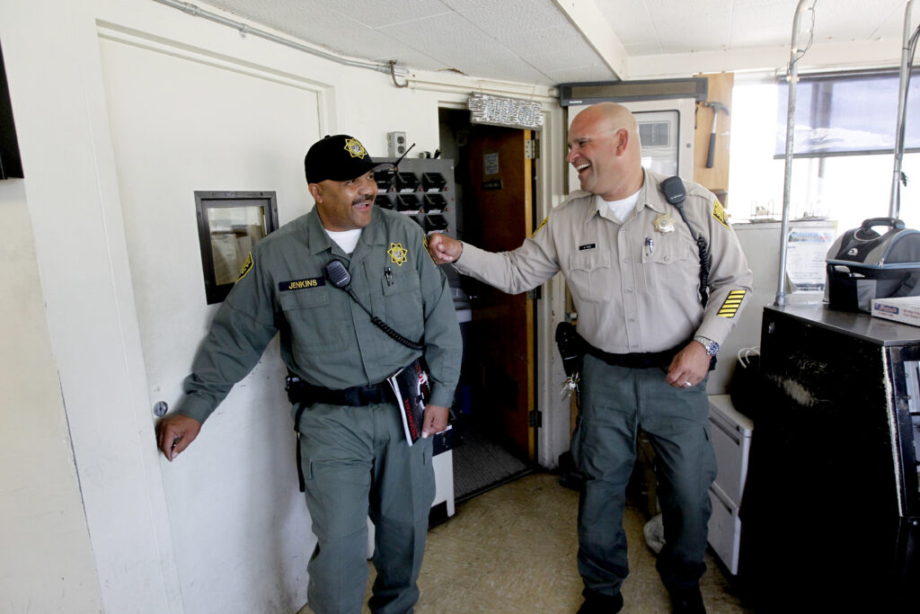 A colleague fist pumps Ron Jenkins' shoulder. 