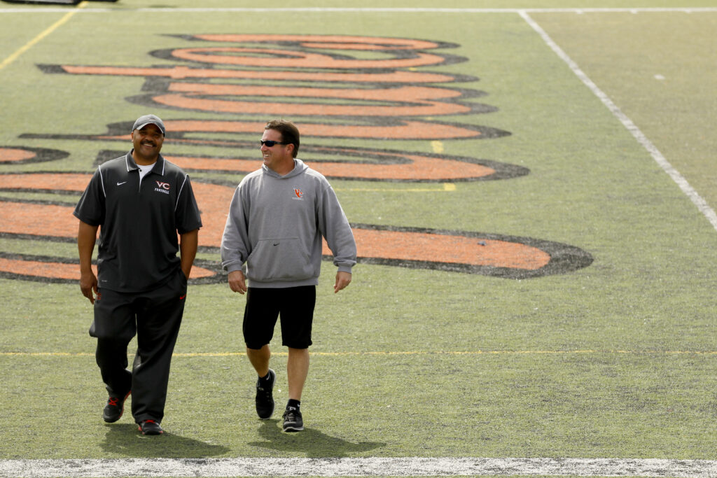 Ron Jenkins and friend walks a football field.