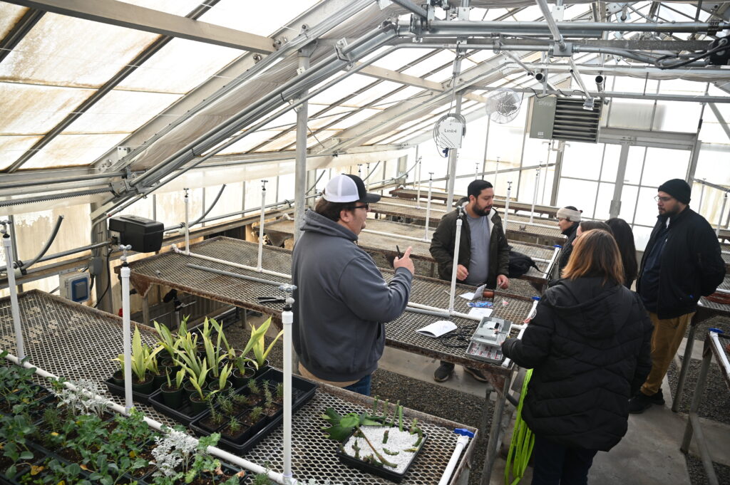 A handful of people stand in the Fresno State nursery where new technology was introduced.