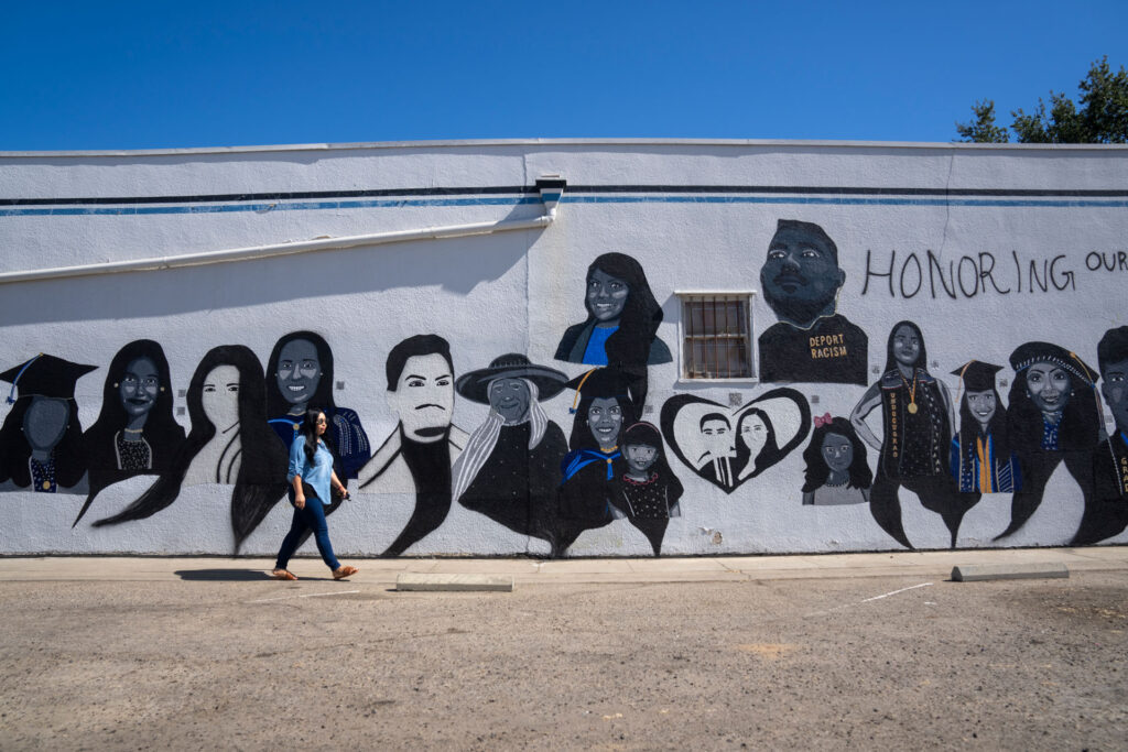Dr. Lizbeth De La Cruz Santana walks in front of the mural in Central Fresno.
