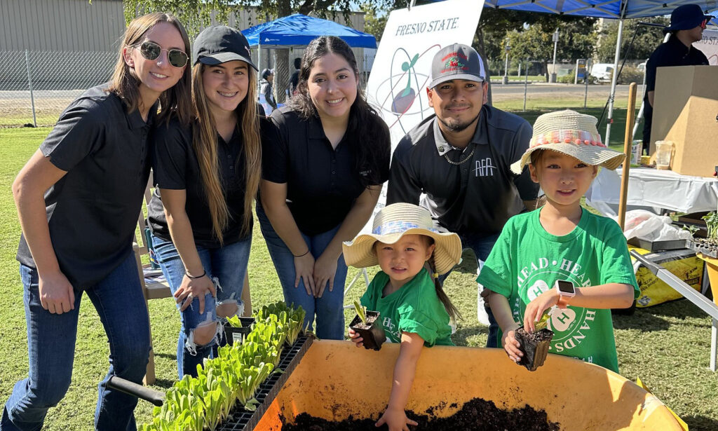 Plant science students host a planting demonstration with youth.