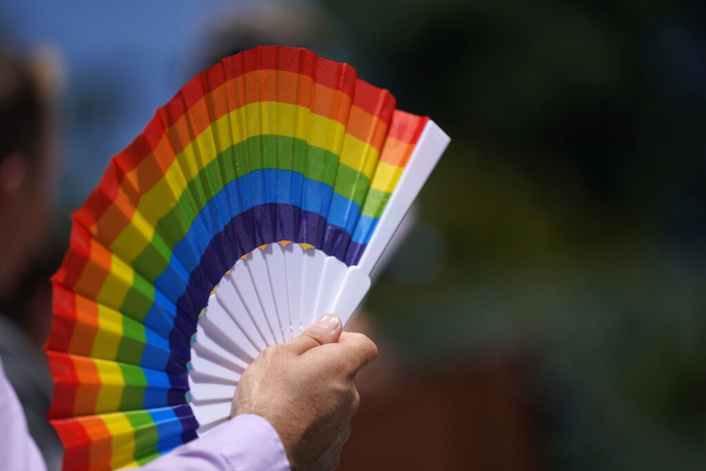 A rainbow folding hand fan.