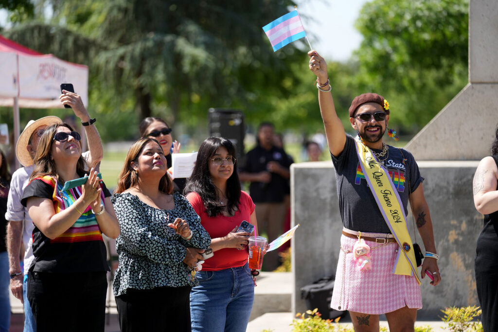 Dr. Ángel de Jesus González wave the transgender flag at a June 2025 Pride Month event.