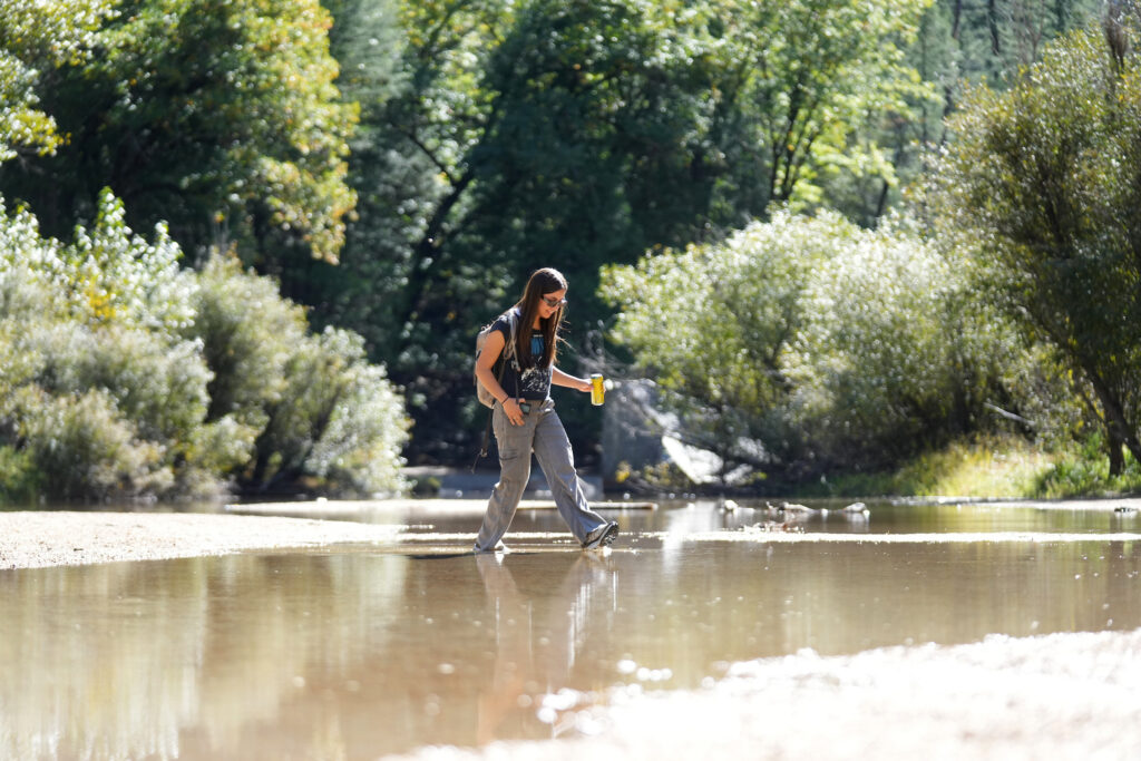 A student wades through a stream
