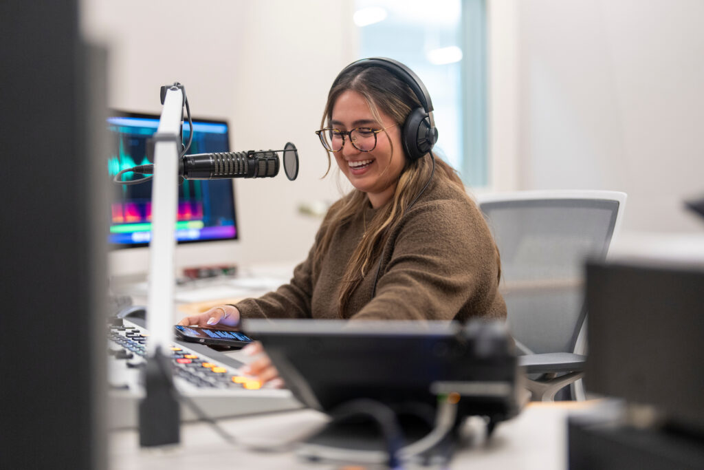 Samantha Rangel, in the KVPR-Valley Public Radio studio, smiles as she talks into a microphone.