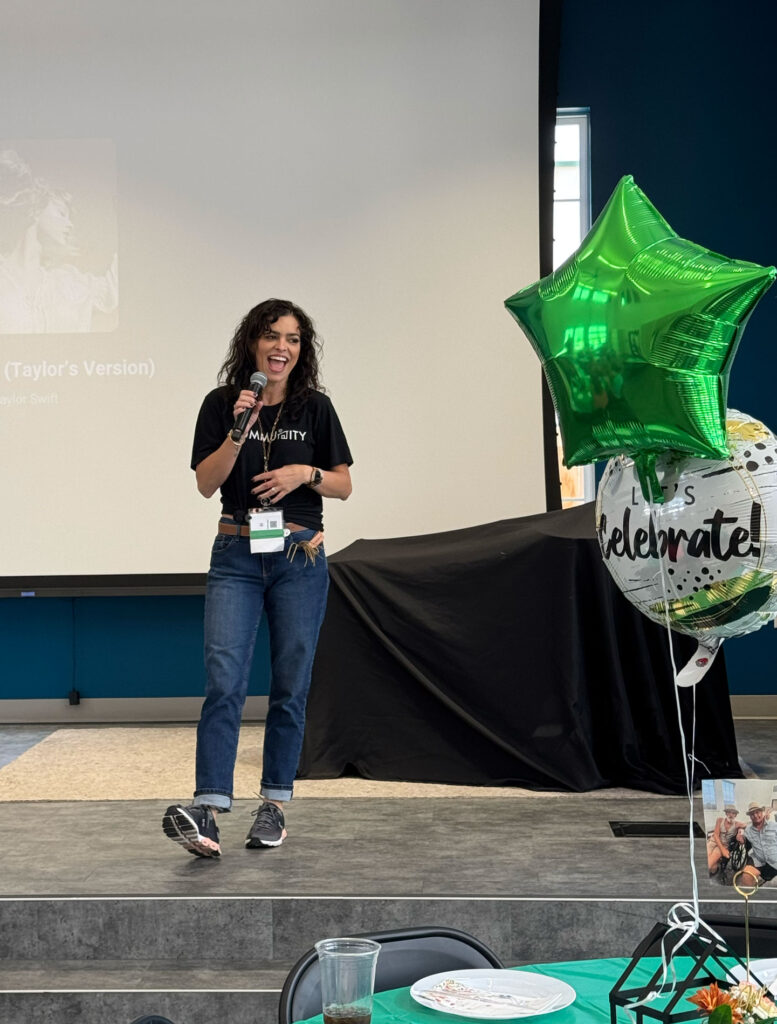 Adrianne Hillman on stage with a microphone.