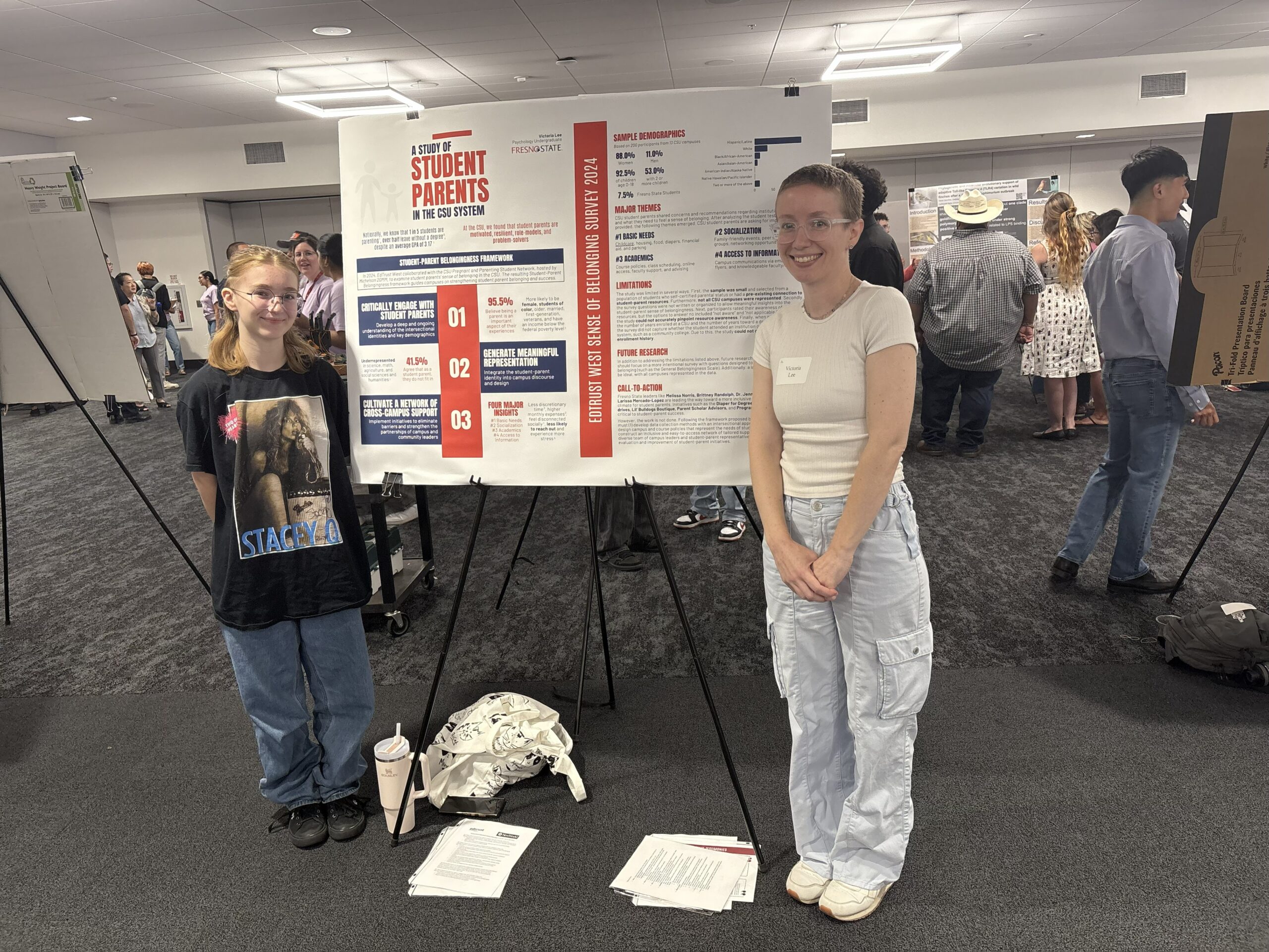 This photograph features Victoria Lee (right) and her daughter (left), both smiling, posing next to Victoria's research presentation at a recent research symposium at Fresno State. 