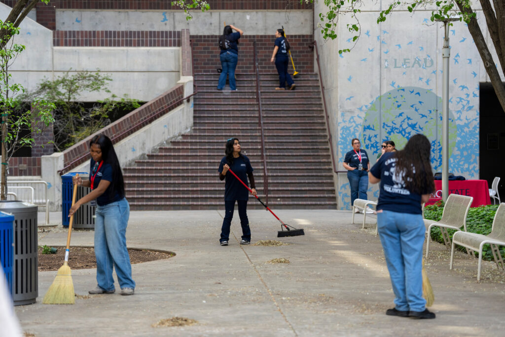 Students working on cleaning Peters Building plaza