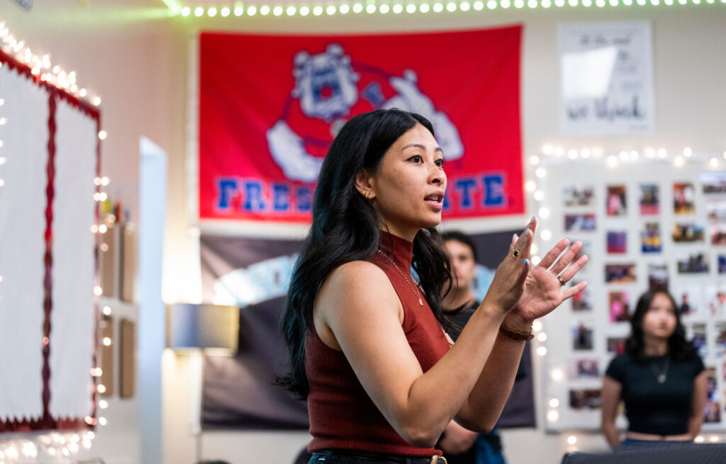 Chrizia Dela Rosa in her classroom in front of a Fresno State flag.