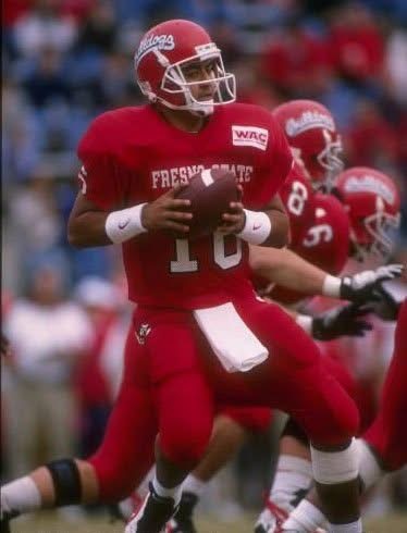 Jim Arellanes drops back to pass in his all red Bulldogs uniform.