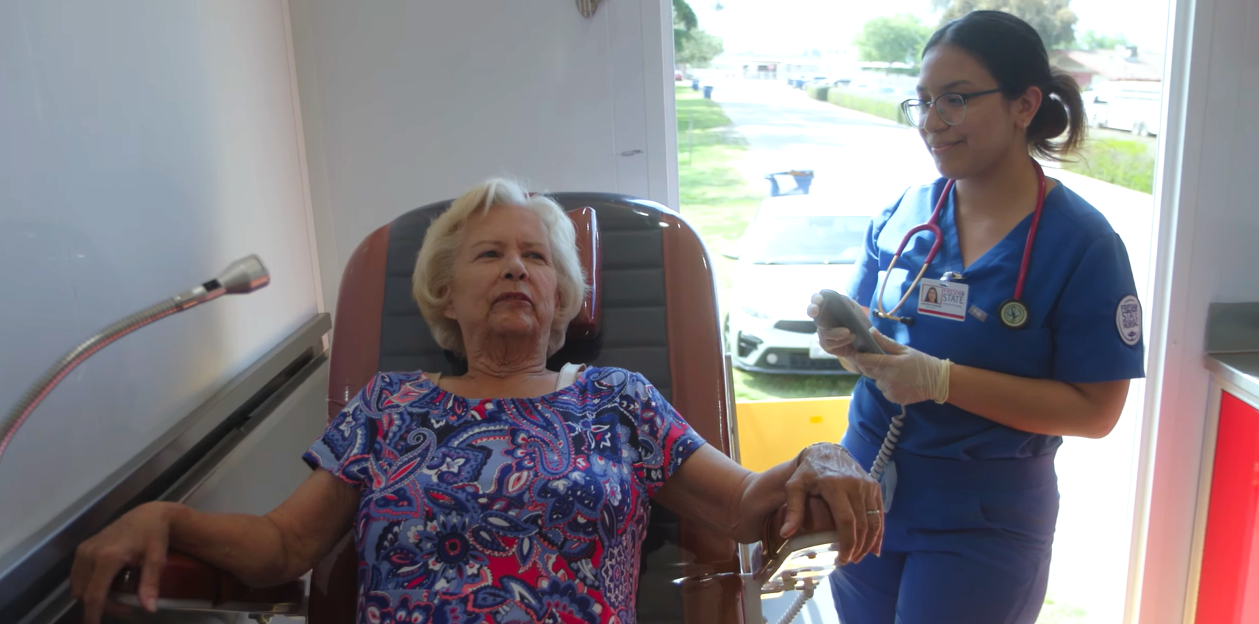A Fresno State nursing student checks a patient’s vital signs inside a mobile health unit.